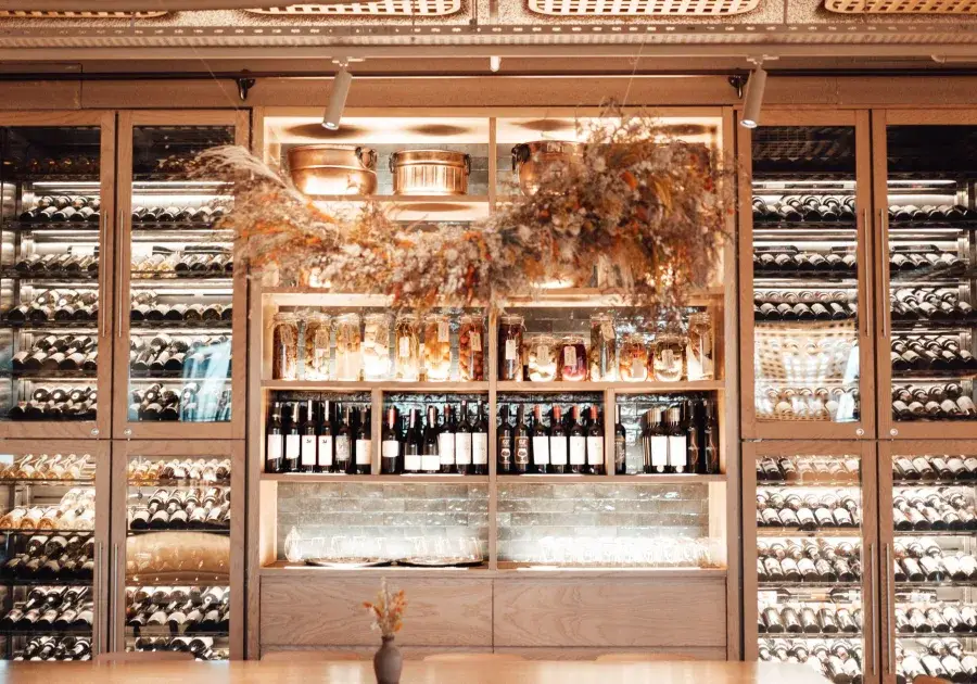 Wine cooler with bottles resting on wooden shelves